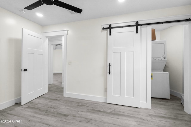 5408 Lagoon Way Unit 5, Panama City, FL 32408 - unfurnished bedroom featuring visible vents, stacked washer and clothes dryer, wood finished floors, a barn door, and baseboards