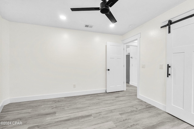 5408 Lagoon Way Unit 5, Panama City, FL 32408 - spare room featuring a ceiling fan, baseboards, visible vents, a barn door, and light wood-type flooring