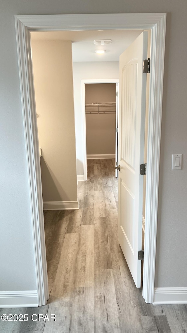 hallway with wood finished floors and baseboards