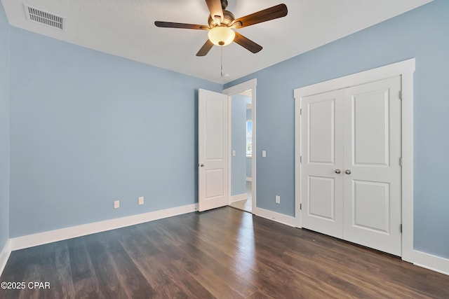 117 Cedar Hammock Ln, Panama City Beach, FL 32407 - unfurnished bedroom with dark wood-style floors, baseboards, a closet, and a ceiling fan