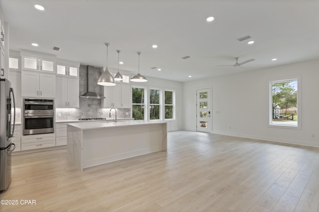17 Woodland Dr, Santa Rosa Beach, FL 32459 - kitchen featuring open floor plan, visible vents, wall chimney exhaust hood, and tasteful backsplash