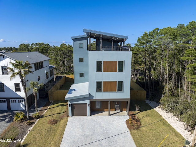 17 Woodland Dr, Santa Rosa Beach, FL 32459 - contemporary home featuring a balcony, a garage, a front yard, and decorative driveway