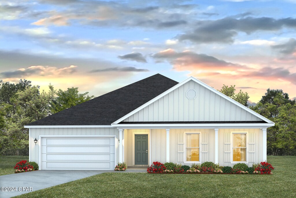 4870 Forest Dunes Dr, Panama City, FL 32404 - view of front facade featuring concrete driveway, roof with shingles, board and batten siding, a front lawn, and a garage