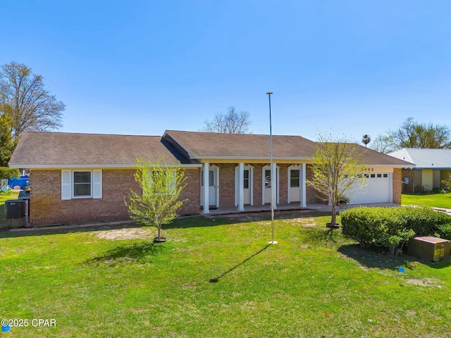 single story home featuring an attached garage, a front lawn, and brick siding
