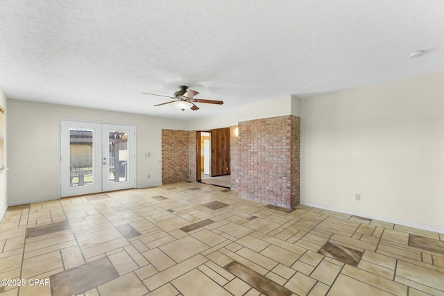 unfurnished room with french doors, a ceiling fan, baseboards, and a textured ceiling