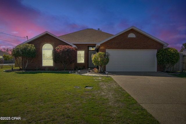 ranch-style home with a garage, a lawn, brick siding, and driveway