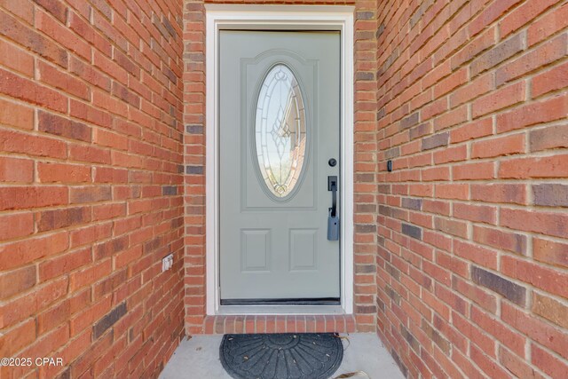 property entrance featuring brick siding
