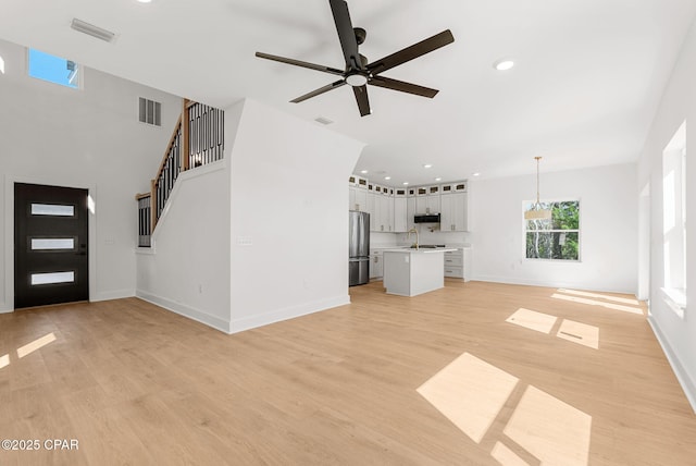 420 Lacosta Ave, Panama City, FL 32404 - unfurnished living room featuring recessed lighting, light wood-type flooring, ceiling fan with notable chandelier, baseboards, and visible vents