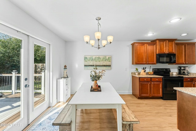 1527 Wateroak Dr, Lynn Haven, FL 32444 - kitchen featuring black appliances, light wood-style flooring, a chandelier, brown cabinets, and decorative light fixtures