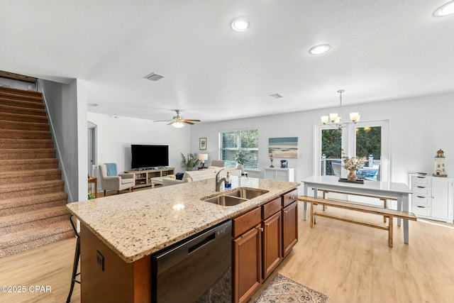 1527 Wateroak Dr, Lynn Haven, FL 32444 - kitchen featuring a sink, dishwasher, brown cabinetry, light wood-style flooring, and an island with sink