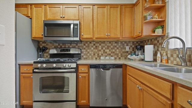 kitchen featuring appliances with stainless steel finishes, light countertops, open shelves, and a sink