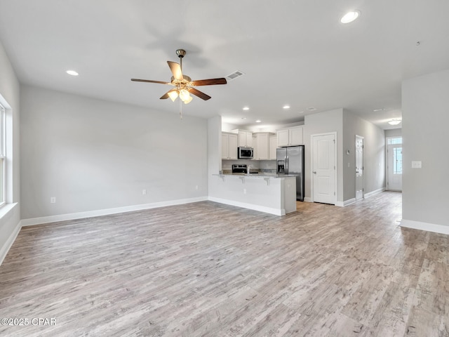 unfurnished living room with light wood finished floors, visible vents, baseboards, ceiling fan, and recessed lighting