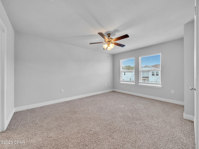 empty room featuring carpet flooring, baseboards, and ceiling fan
