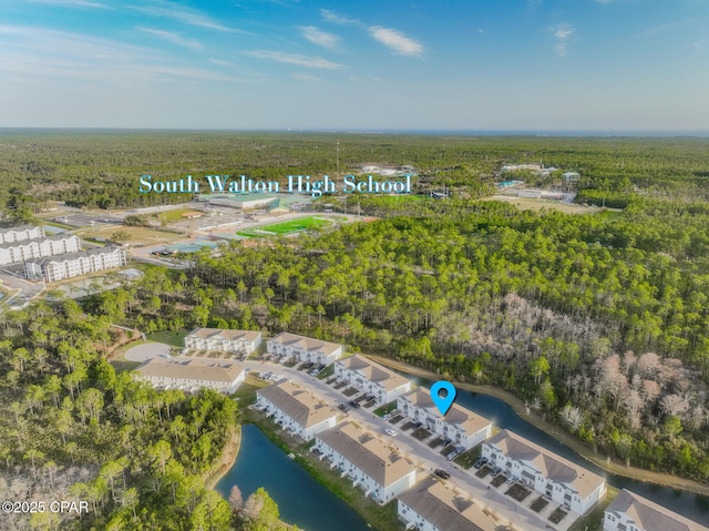 bird's eye view featuring a wooded view and a water view
