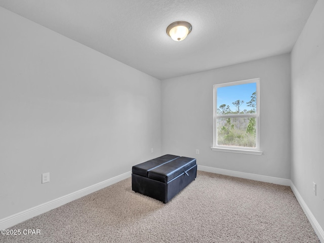 unfurnished room with carpet and baseboards