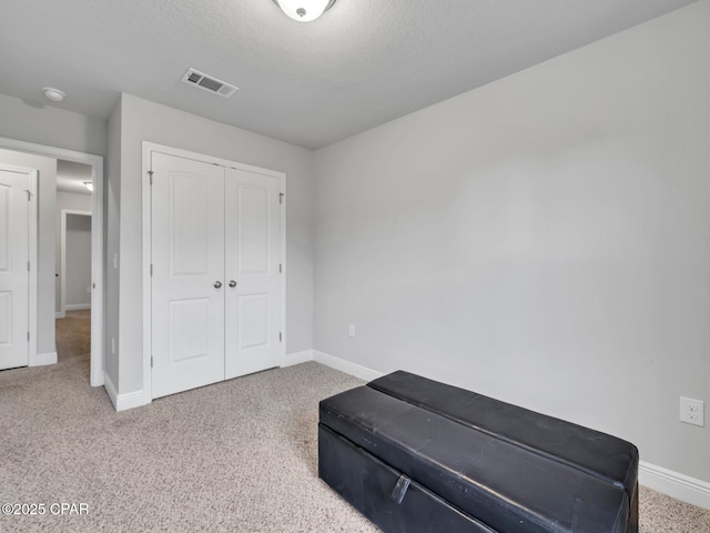 bedroom featuring a closet, visible vents, carpet flooring, and baseboards