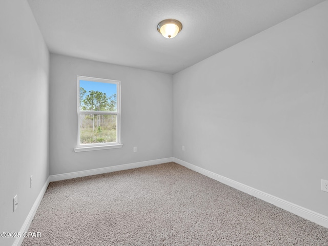 carpeted spare room featuring baseboards