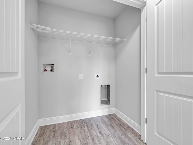 clothes washing area featuring hookup for an electric dryer, wood finished floors, baseboards, and washer hookup