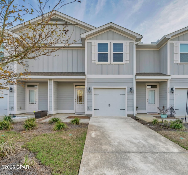 multi unit property featuring an attached garage, concrete driveway, and board and batten siding