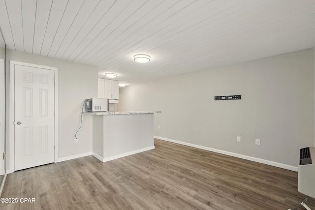 5505 Sun Harbor Rd Unit 143, Panama City, FL 32401 - kitchen featuring a peninsula, baseboards, wood finished floors, and white cabinetry