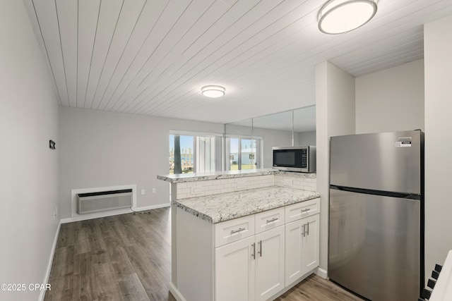 5505 Sun Harbor Rd Unit 143, Panama City, FL 32401 - kitchen featuring a wall mounted AC, wood ceiling, white cabinets, a peninsula, and appliances with stainless steel finishes