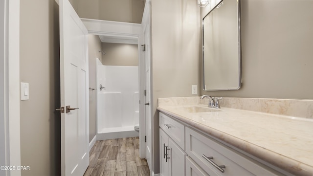 5301 Alexander Ln, Panama City, FL 32404 - bathroom featuring toilet, vanity, wood finished floors, and a walk in shower