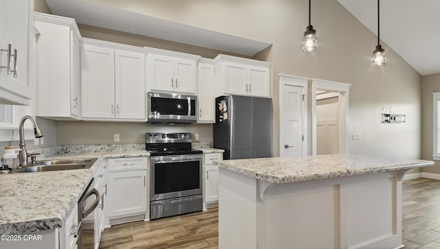 5301 Alexander Ln, Panama City, FL 32404 - kitchen with a sink, light wood-type flooring, a center island, appliances with stainless steel finishes, and white cabinetry