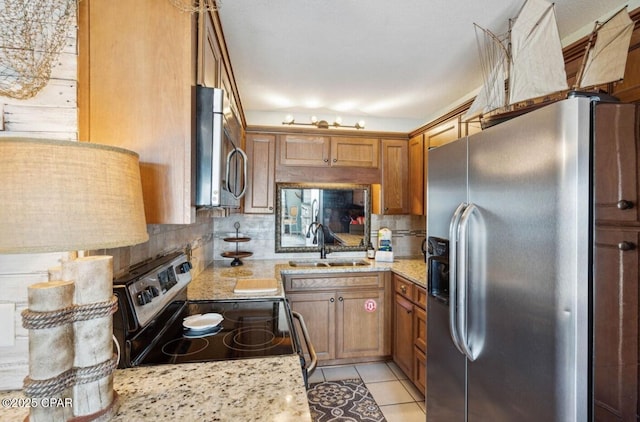8743 Thomas Dr Unit 225, Panama City Beach, FL 32408 - kitchen with brown cabinets, tasteful backsplash, stainless steel appliances, and a sink