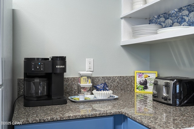 9900 S Thomas Dr Unit 425, Panama City, FL 32408 - kitchen with blue cabinetry, dark stone counters, and a toaster