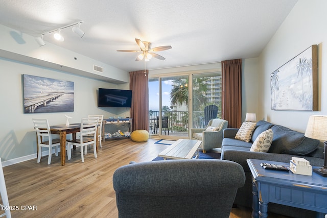9900 S Thomas Dr Unit 425, Panama City, FL 32408 - living room featuring a ceiling fan, visible vents, a textured ceiling, and wood finished floors