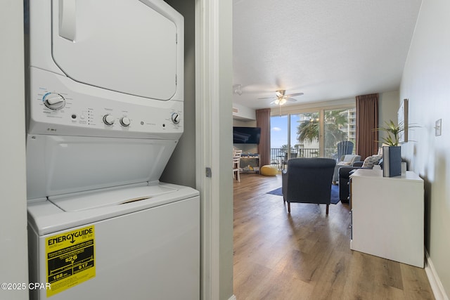 9900 S Thomas Dr Unit 425, Panama City, FL 32408 - clothes washing area featuring a ceiling fan, stacked washer and clothes dryer, a textured ceiling, and wood finished floors