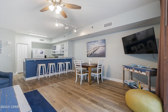 9900 S Thomas Dr Unit 425, Panama City, FL 32408 - dining room with baseboards, visible vents, a ceiling fan, and wood finished floors