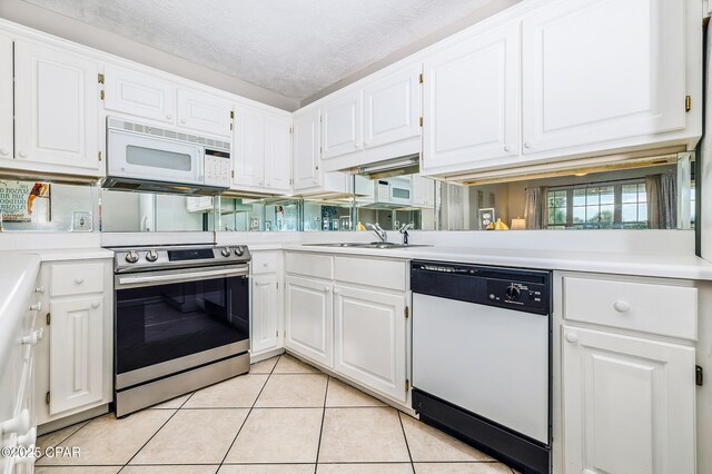 17462 Front Beach Rd Unit 56206, Panama City Beach, FL 32413 - kitchen featuring white appliances, a sink, light countertops, light tile patterned floors, and a textured ceiling