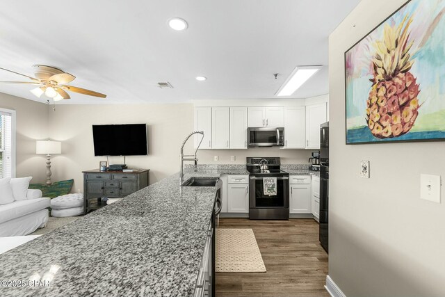 17690 Front Beach Rd Unit D307, Panama City Beach, FL 32413 - kitchen with a sink, light stone counters, open floor plan, stainless steel appliances, and white cabinets