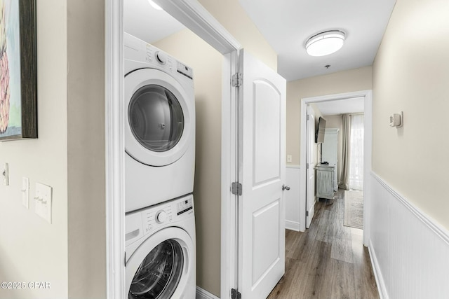 17690 Front Beach Rd Unit D307, Panama City Beach, FL 32413 - laundry area with laundry area, wainscoting, stacked washer and clothes dryer, and wood finished floors