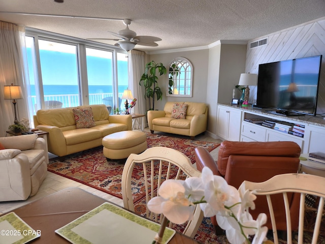 7205 Thomas Dr Unit E706, Panama City, FL 32408 - living area with ornamental molding, a ceiling fan, a textured ceiling, and a water view