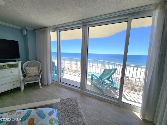 7205 Thomas Dr Unit E706, Panama City, FL 32408 - bedroom featuring view of water and beach, access to outside, crown molding, and a textured ceiling
