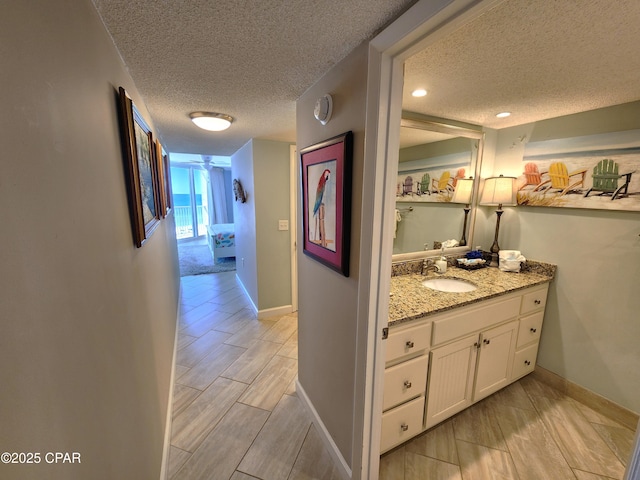 7205 Thomas Dr Unit E706, Panama City, FL 32408 - hallway with a sink, a textured ceiling, baseboards, and wood tiled floors