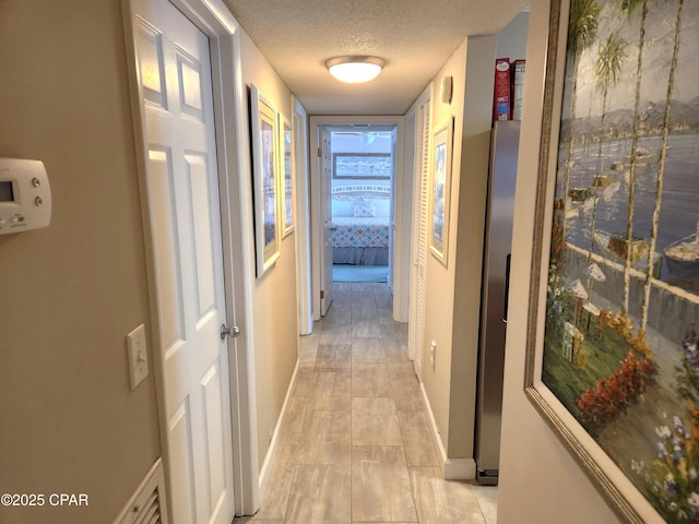 7205 Thomas Dr Unit E706, Panama City, FL 32408 - hallway featuring a textured ceiling and baseboards