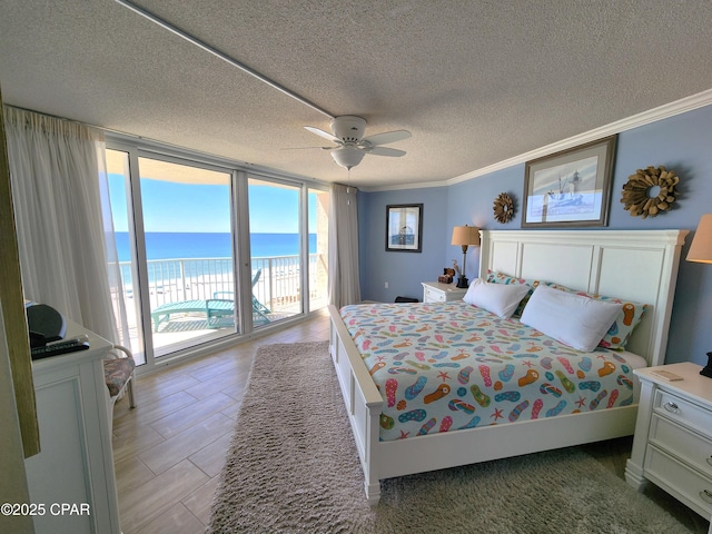 7205 Thomas Dr Unit E706, Panama City, FL 32408 - bedroom featuring access to exterior, expansive windows, a textured ceiling, ornamental molding, and a water view
