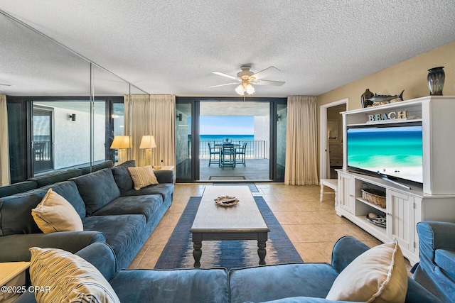 6201 Thomas Dr Unit 406, Panama City Beach, FL 32408 - living area with a textured ceiling, floor to ceiling windows, light tile patterned flooring, and a ceiling fan