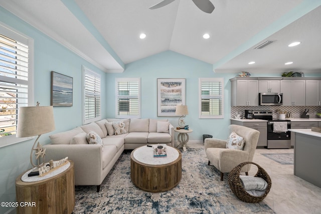 living room featuring plenty of natural light, a ceiling fan, vaulted ceiling, and visible vents