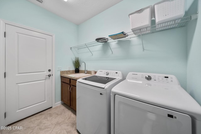 laundry area with a sink, baseboards, cabinet space, and washer and clothes dryer