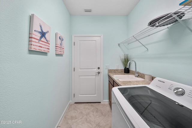 laundry area featuring laundry area, a sink, washer / clothes dryer, baseboards, and visible vents
