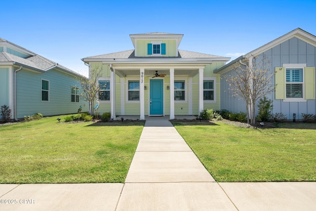 bungalow-style home with a ceiling fan, a front lawn, and board and batten siding