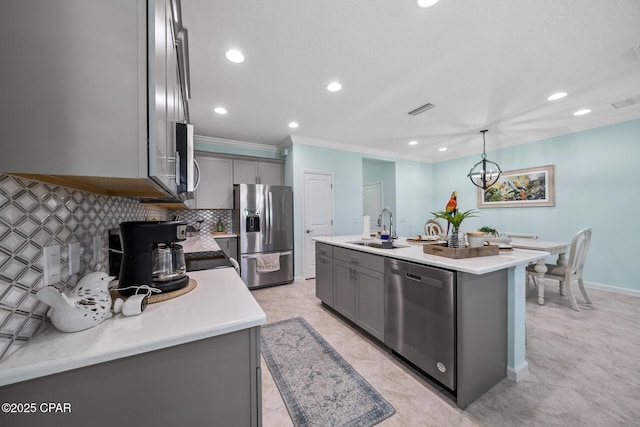 kitchen with a sink, gray cabinets, appliances with stainless steel finishes, and ornamental molding