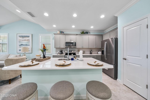 kitchen featuring visible vents, appliances with stainless steel finishes, tasteful backsplash, a sink, and gray cabinetry