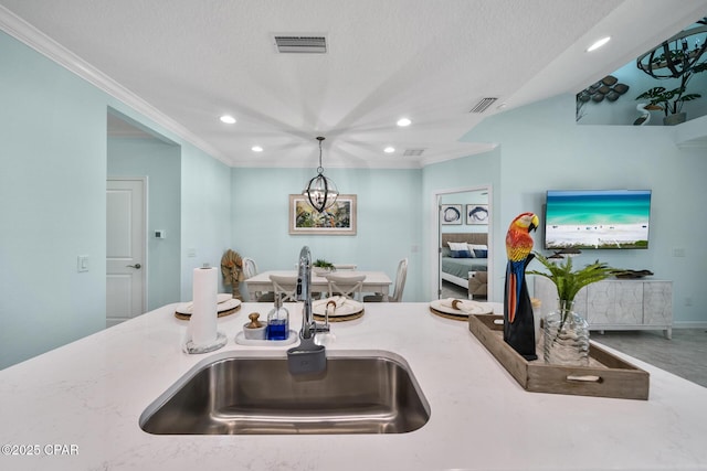 kitchen with visible vents, crown molding, recessed lighting, a textured ceiling, and a sink