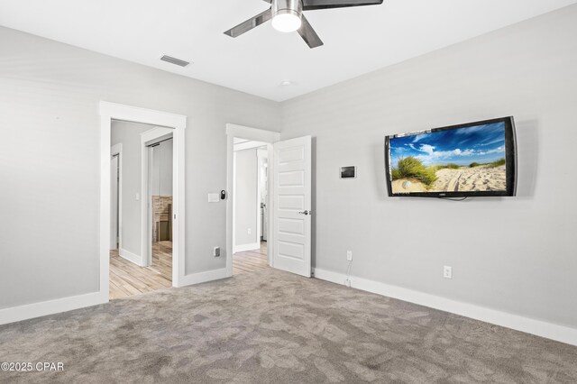 unfurnished bedroom featuring baseboards, visible vents, carpet flooring, and a ceiling fan