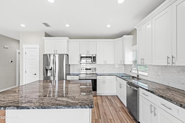 kitchen featuring visible vents, white cabinets, a sink, and appliances with stainless steel finishes